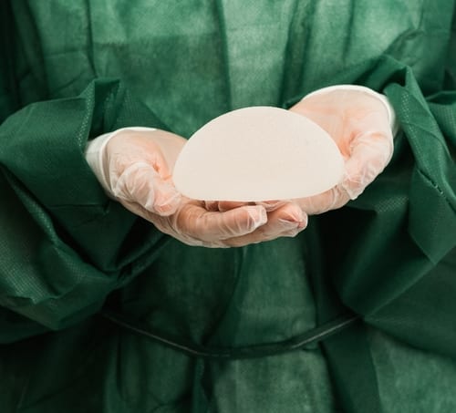 Surgeon holding silicone breast implant.