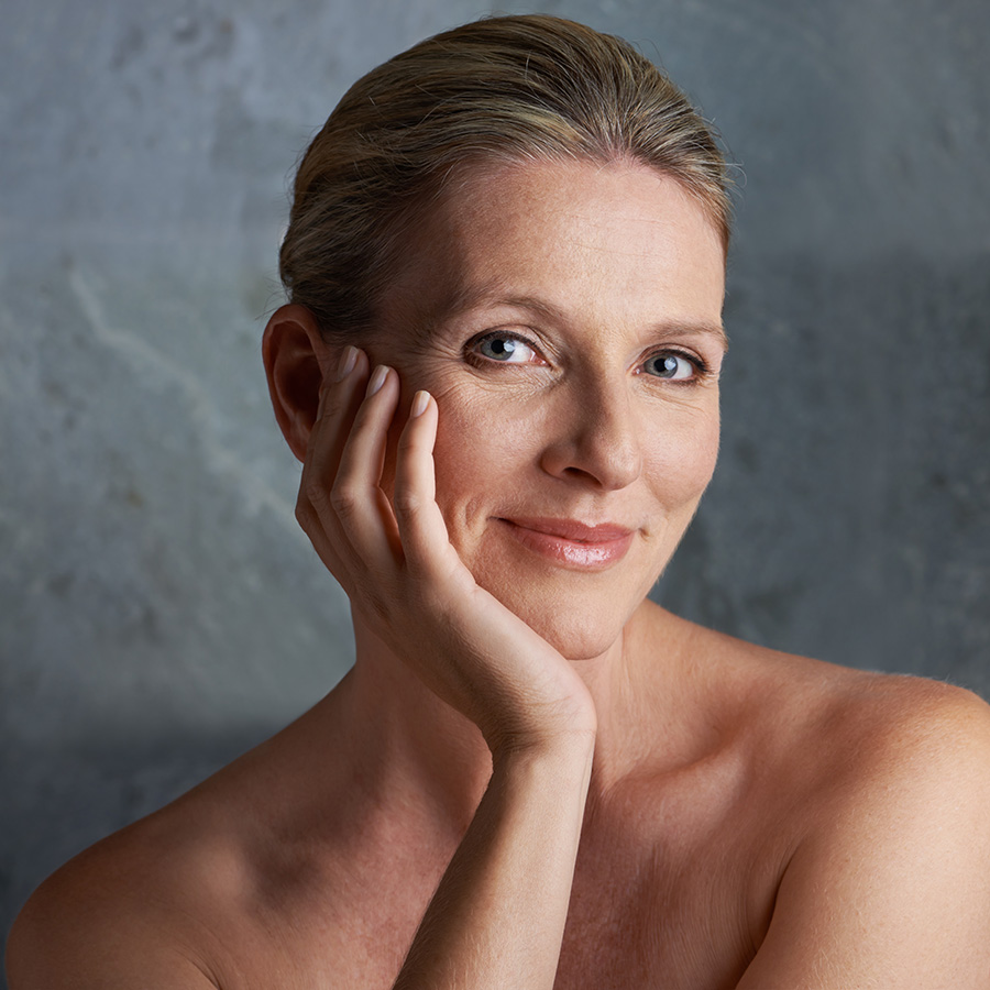 Mature woman with her had on her chin