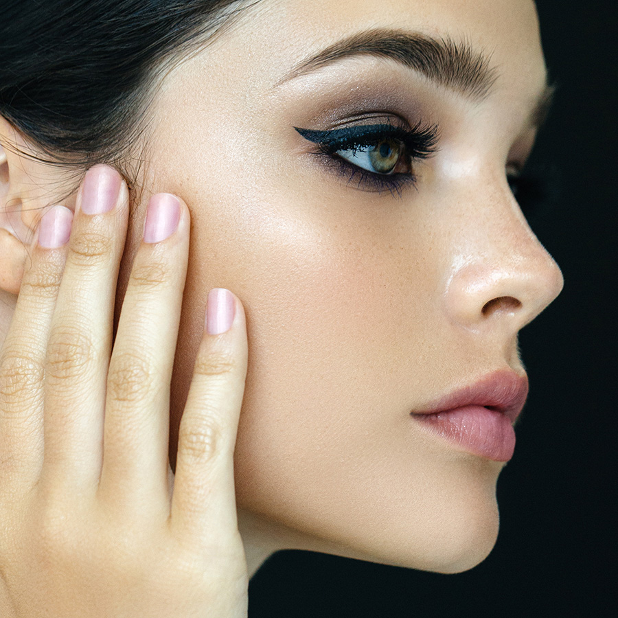 Young woman with nice skin touching her face