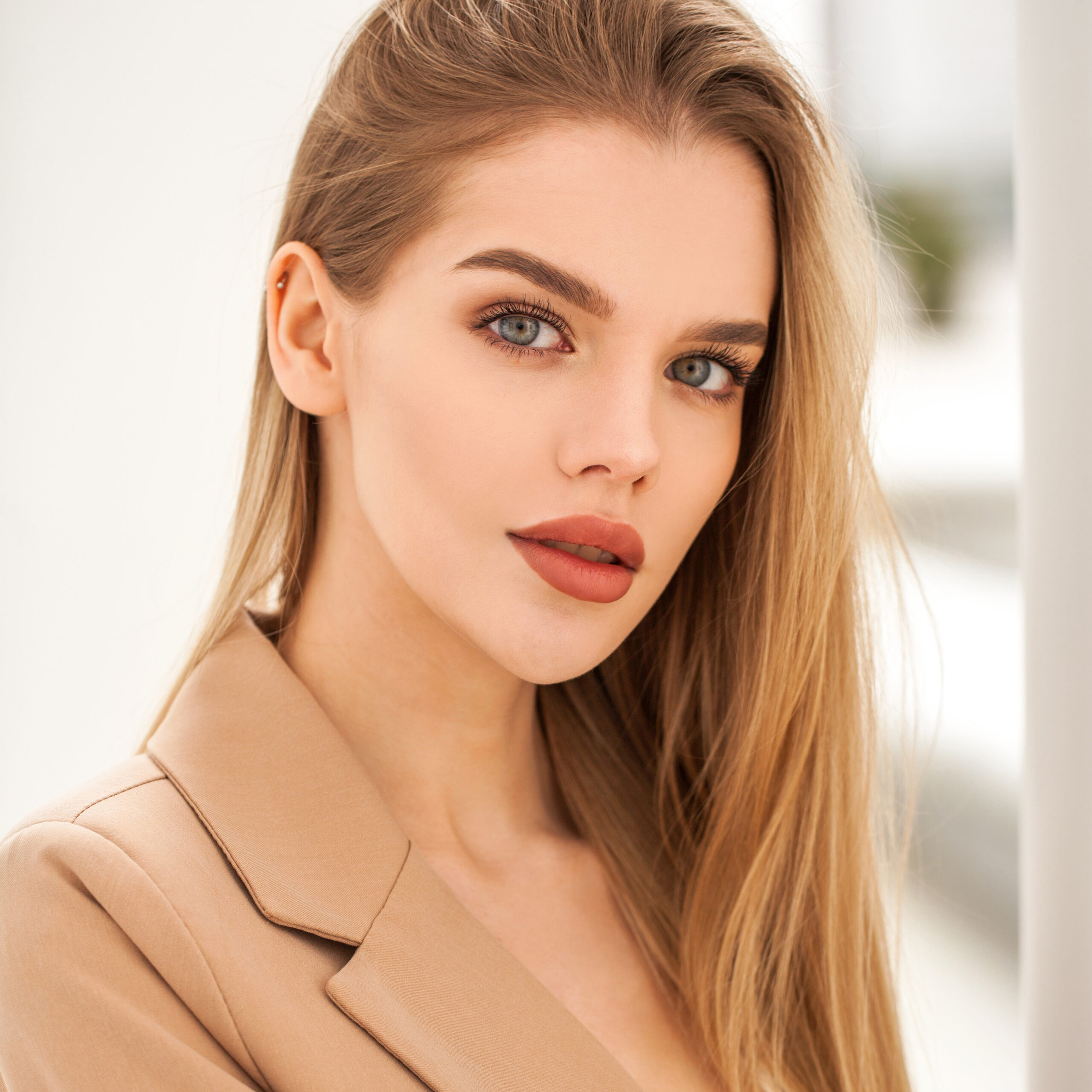 Beautiful woman in tan coat with red lipstick